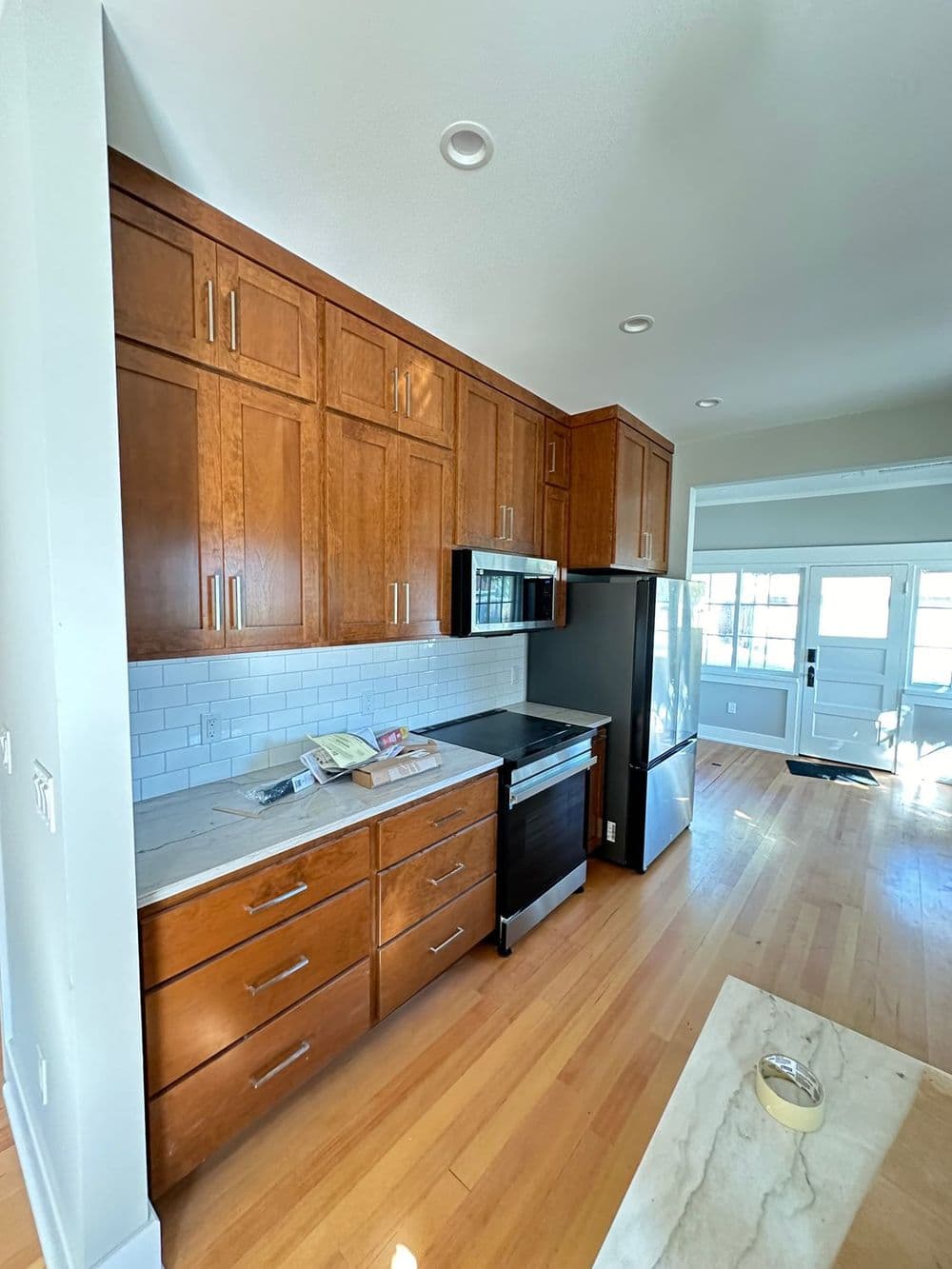 Modern kitchen featuring wooden cabinets, stainless steel appliances, and hardwood flooring.