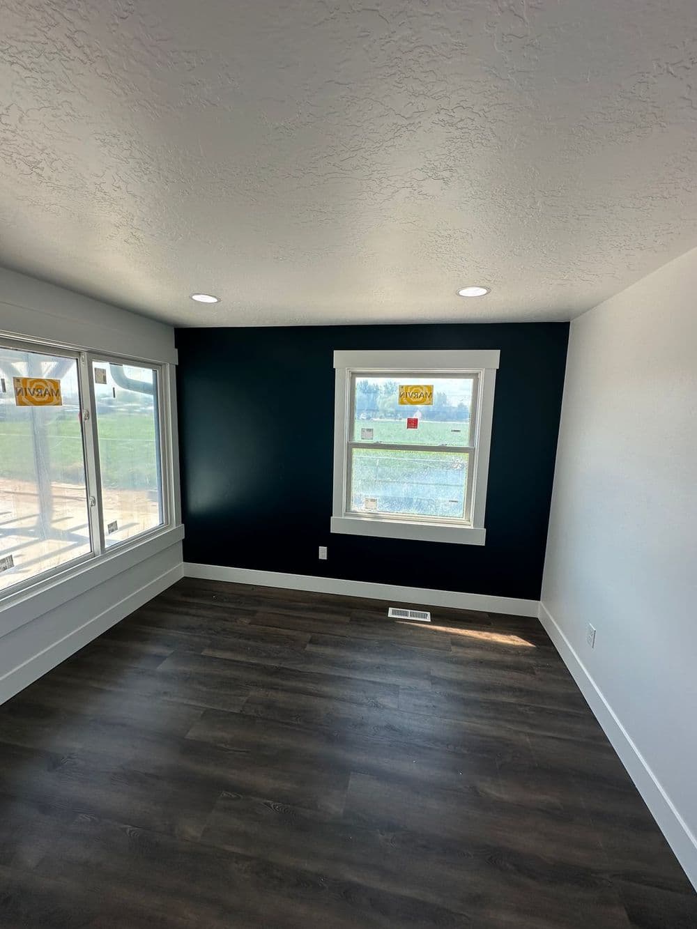 Bright room with dark blue accent wall and large windows letting in natural light.