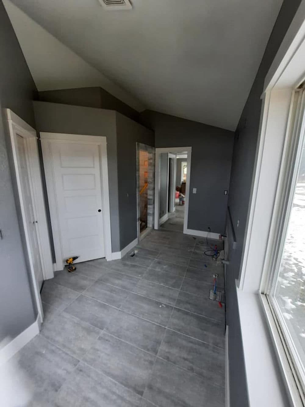 Interior view of a modern hallway featuring gray walls and tile flooring.