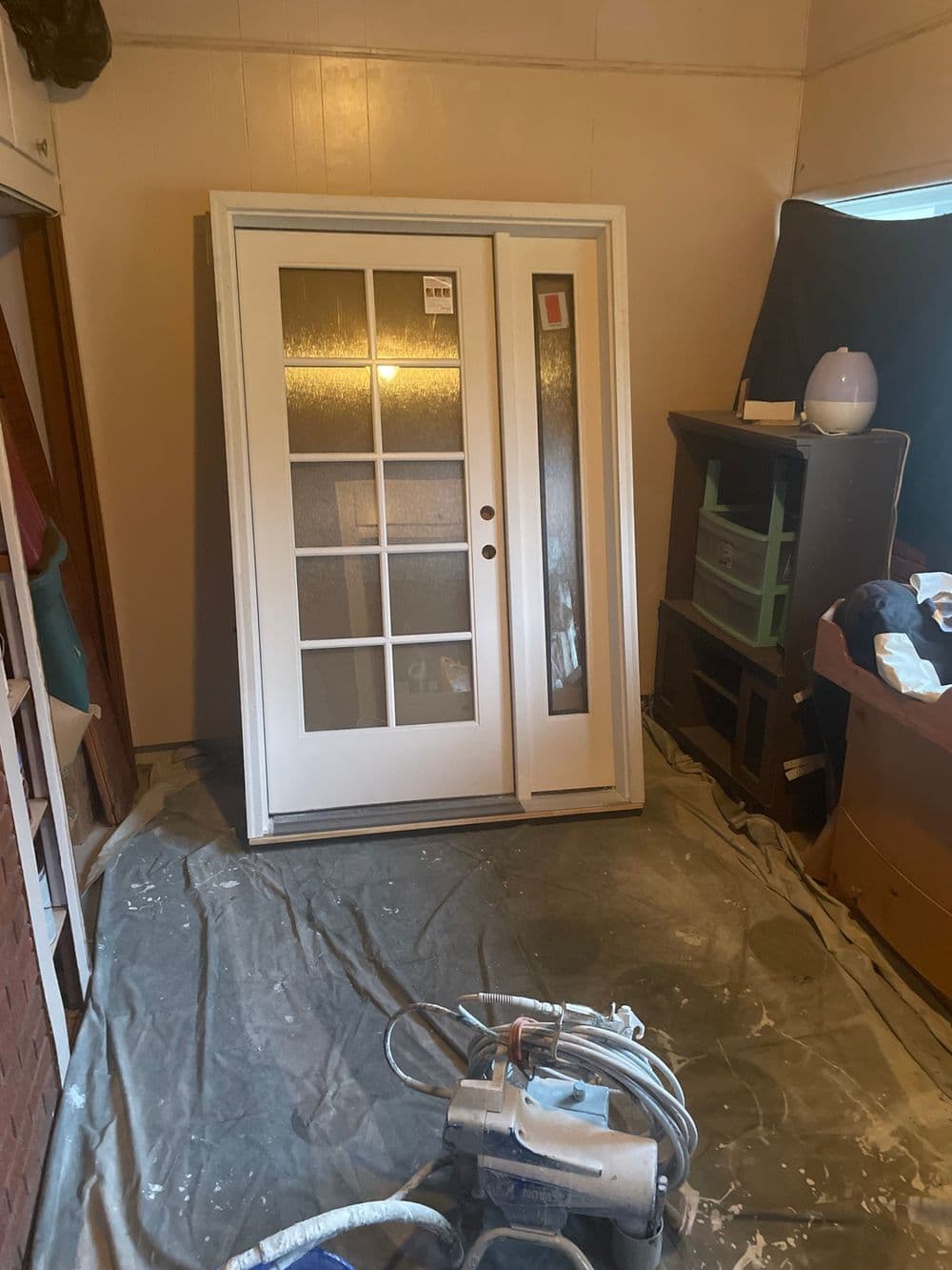 New double door with glass panels, sitting in a room with construction materials.